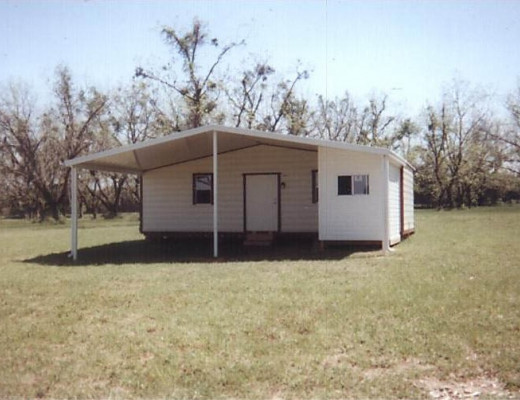 White aluminum carport attached to mobile home